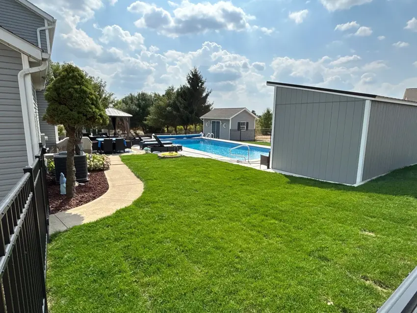 Finished green lawn near a backyard pool after sod installation by Going Yard